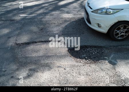 Grande Missenden, Regno Unito. 20 aprile 2023. Grandi buche stavano causando un traffico lento a Great Missenden, nel Buckinghamshire. Sfortunatamente molte buche in tutto il Consiglio del Buckinghamshire sono alla fine riparate, ma entro poche settimane dopo la pioggia e il freddo, le buche ritornano. Oggi le auto stavano deviando nel percorso dei veicoli in arrivo per evitare buche. Il governo ha accantonato altri 200 milioni di sterline per le riparazioni della buche nel periodo 2023-2024. Credito: Maureen McLean/Alamy Foto Stock