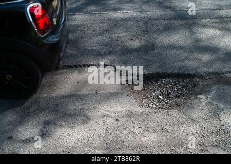 Grande Missenden, Regno Unito. 20 aprile 2023. Grandi buche stavano causando un traffico lento a Great Missenden, nel Buckinghamshire. Sfortunatamente molte buche in tutto il Consiglio del Buckinghamshire sono alla fine riparate, ma entro poche settimane dopo la pioggia e il freddo, le buche ritornano. Oggi le auto stavano deviando nel percorso dei veicoli in arrivo per evitare buche. Il governo ha accantonato altri 200 milioni di sterline per le riparazioni della buche nel periodo 2023-2024. Credito: Maureen McLean/Alamy Foto Stock