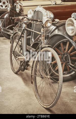 Bicicletta d'epoca di fronte alle classiche auto dei primi del Novecento Foto Stock