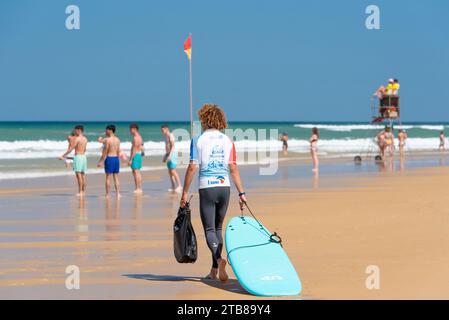 Biscarosse-(Francia sud-occidentale): Biscarosse-Plage, spiaggia e luogo per il surf. Istruttore della scuola francese di surf sulla sabbia. Sullo sfondo, nuotatori Foto Stock