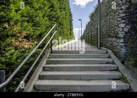 Scale con ringhiere metalliche su una strada stretta fiancheggiata Foto Stock