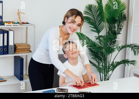 Un ragazzo con un insegnante impara a svilupparsi nello studio dello psicologo Foto Stock