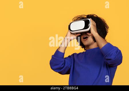 Giovane afro-americano che usa occhiali VR Foto Stock