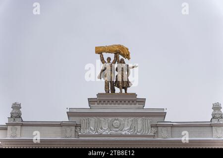 20 dicembre 2022. Mosca. Russia.: Scultura d'oro Tractor driver e Collective Farm Woman sull'arco dell'ingresso principale di VDNKh contro il cielo Foto Stock