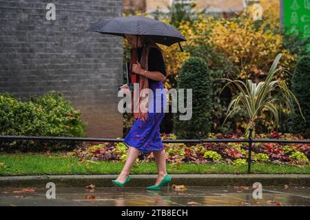 Londra Regno Unito. 5 dicembre 2023. Un personale di Downing Street si rifugia con un ombrello in una giornata piovosa e umida a Londra. Crediti: amer ghazzal/Alamy Live News . Foto Stock