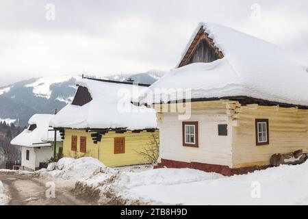 Architettura folcloristica in un paesaggio invernale innevato. Villaggio di Vlkolinec con storiche case in legno colorate, Slovacchia Europa. Foto Stock