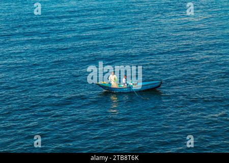 I venditori di tessuti sulle loro barche si avvicinano a una nave da crociera in attesa di entrare nella chiusa di Esna. I venditori sperano di vendere beni ai turisti. Esna, Egitto – 20 ottobre Foto Stock