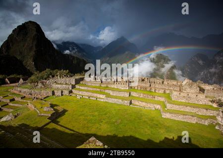 Gli arcobaleni si formano sopra le rovine di Machu Picchu; Perù Foto Stock