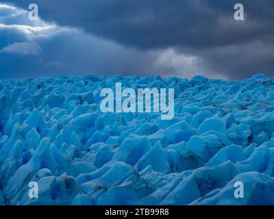 Ghiaccio blu proveniente dal ghiacciaio Grigio che scende dal terzo più grande campo di ghiaccio, il campo di ghiaccio della Patagonia meridionale nel Parco Nazionale di Torres del Paine Foto Stock