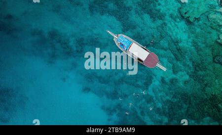 Vista aerea dell'uomo che nuota nell'acqua turchese dell'oceano Foto Stock