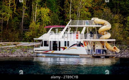 Una famiglia che si gode una vacanza in casa galleggiante mentre è parcheggiata sulla riva del lago Shuswap; lago Shuswap, British Columbia, Canada Foto Stock