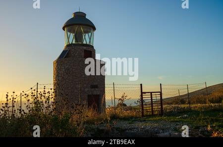 Faro al tramonto a Saranda Albania. Fanar Saranda. Faro Head affacciato sul mare Ionio. Messa a fuoco selettiva, spazio copia. Foto Stock