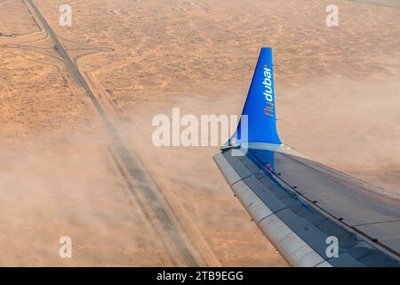 Dubai, Emirati Arabi Uniti - 12 ottobre 2023: Ala aerea con logo Fly Dubai Airlines sul deserto Foto Stock