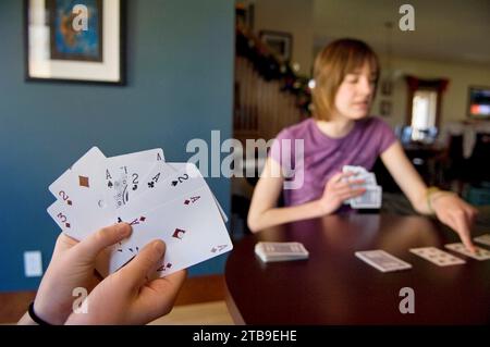 La ragazza gioca a carte Solitaire in casa; Lincoln, Nebraska, Stati Uniti d'America Foto Stock