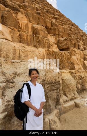Primo piano di una donna turistica asiatica di fronte alla grande Piramide di Giza; Giza, il Cairo, Egitto Foto Stock