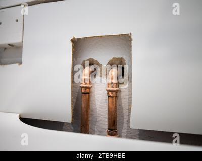 Tubi di rame per l'acqua in un appartamento. Le tubazioni sono installate nella cucina dell'appartamento. Sono importanti per il riscaldamento e per l'acqua calda. Foto Stock