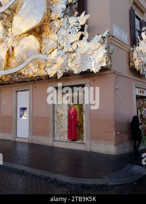 Vetrina con abito rosso e decorazioni natalizie nella città di Roma, regione Lazio, Italia, 5 dicembre 2023 Foto Stock