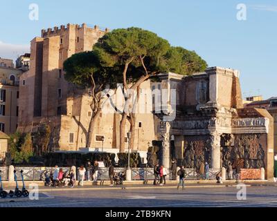 Antichi edifici con pini di pietra e pedoni di fronte in una serata d'autunno nella città di Roma, regione Lazio, Italia, 5 dicembre 2023 Foto Stock