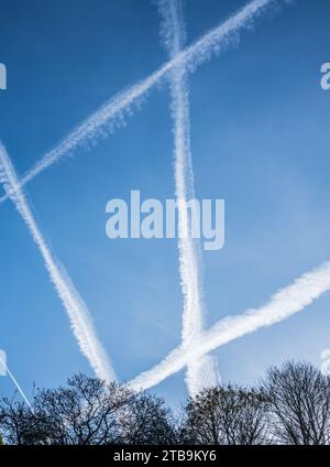 Vapour trail da alti getti volanti contro un cielo azzurro. Foto Stock