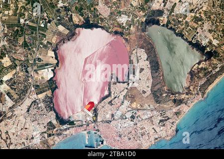 Vista dallo spazio delle lagune di sale e delle acque intorno alla città portuale di Torrevieja, Spagna. Foto Stock