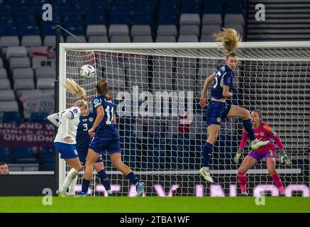 Glasgow, Scozia, Regno Unito. 5 dicembre 2023; Hampden Park, Glasgow, Scozia: UEFA Womens Nations League, Scozia contro Inghilterra; Alex Greenwood dell'Inghilterra guarda il suo headeder battere Emma Mukandi e Lee Gibson della Scozia per segnare e conquistare 0-1 al 13° minuto credito: Action Plus Sports Images/Alamy Live News Foto Stock