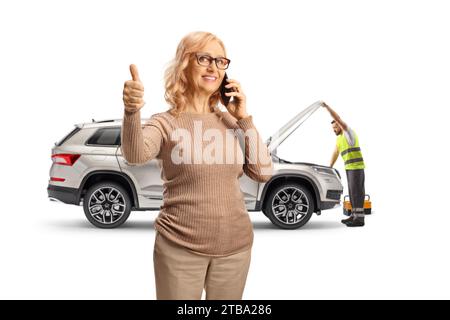 Donna con problemi di auto che chiama un meccanico e che si muove i pollici isolati su sfondo bianco Foto Stock