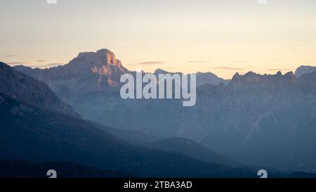 Cima rocciosa della catena montuosa che cattura la prima luce durante l'alba, Dolomiti, Italia Foto Stock