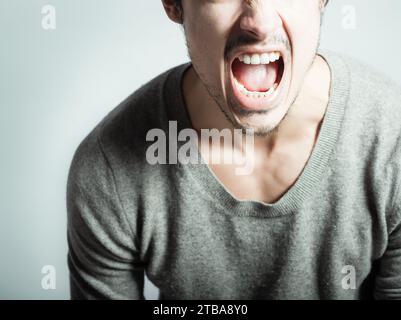 Uomo arrabbiato che urla esprimendo rabbia frustrazione Foto Stock