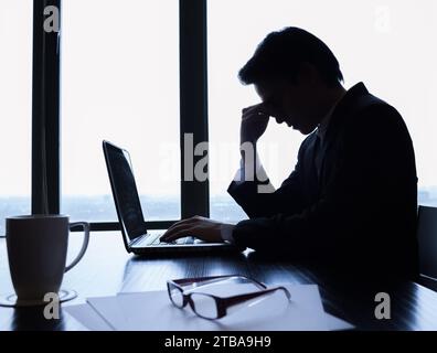 Stanco uomo d'affari nel suo ufficio che vende stress esausto e sovraccarica di lavoro Foto Stock