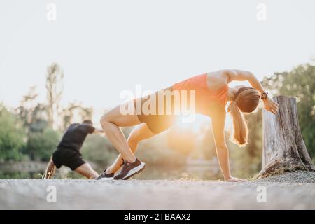 Coppia attiva che si allunga le gambe nel parco naturale per allenarsi all'aperto. Foto Stock