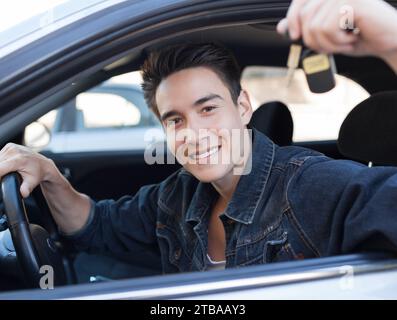 Buon autista maschio. L'uomo comprò la sua prima auto. Concessionaria. Foto Stock