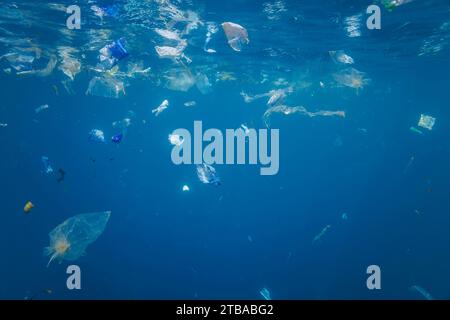 Sacchetti di plastica e rifiuti di vario tipo galleggiano sott'acqua in acqua blu al largo di Baucau, Repubblica democratica di Timor Est. Foto Stock