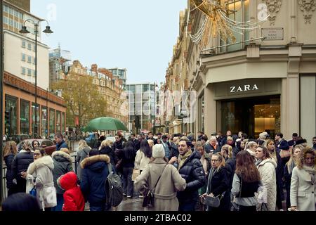 3 dicembre 2023 - Londonuk: Immagine a colori della strada di Londra affollata di amanti dello shopping natalizio nei giorni di pioggia Foto Stock