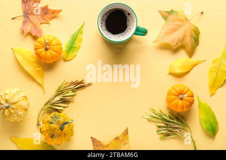 Cornice composta da foglie cadute, zucche e tazza con caffè aromatico su sfondo colorato Foto Stock