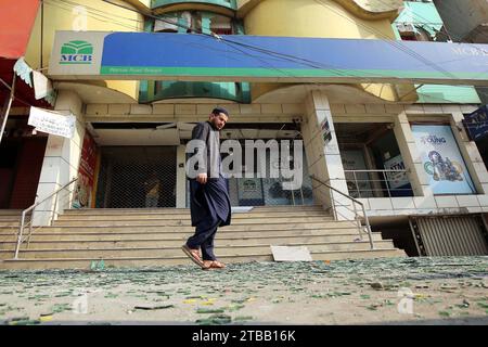 Pechino, Pakistan. 5 dicembre 2023. Un uomo cammina davanti a un edificio danneggiato a seguito di un'esplosione a Peshawar, Pakistan, 5 dicembre 2023. Sette persone, tra cui quattro bambini, sono rimaste ferite in un'esplosione fuori da una scuola nella provincia nordoccidentale di Khyber Pakhtunkhwa in Pakistan martedì, hanno detto le squadre di soccorso. Crediti: Umar Qayyum/Xinhua/Alamy Live News Foto Stock