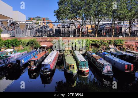 Barche lunghe colorate con riflessi ormeggiate nel Regent's Canal Lisson Grove ormeggio, Lisson Grove, Londra, Inghilterra, Regno Unito Foto Stock