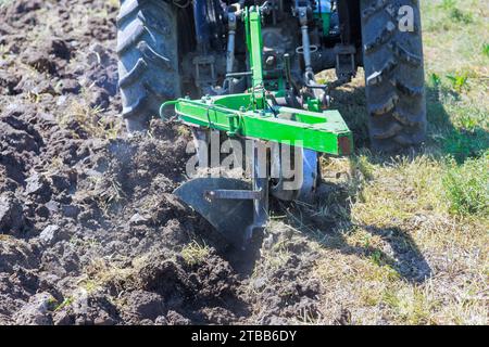 Un agricoltore prepara i terreni per la semina in primavera utilizzando un trattore Foto Stock