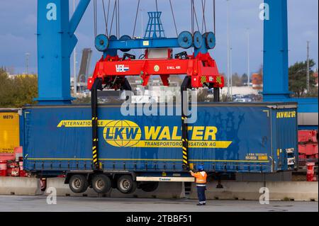 Rostock, Germania. 21 novembre 2023. Un rimorchio dell'azienda di logistica LKW Walter viene caricato su un treno presso il porto marittimo insieme ad altri rimorchi. Diversi centri logistici operano nel porto marittimo di Rostock e gestiscono le merci. Credito: Jens Büttner/dpa/Alamy Live News Foto Stock