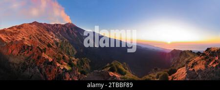 Etna panoramica all'alba con suggestivi colori e vista sul cratere e Valle del Bove con sole all'orizzonte che sorge Foto Stock