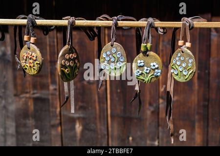 Gruppo di collane colorate dipinte a mano e di souvenir esposti in vendita in un tradizionale mercato del fine settimana a Bucarest, Romania Foto Stock