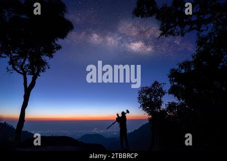 Silhouette di un fotografo professionista che scatta in modo lattiginoso in montagna Foto Stock