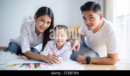 Padre e madre stanno insegnando alla loro figlia a dipingere. C'è calore in famiglia. Foto Stock