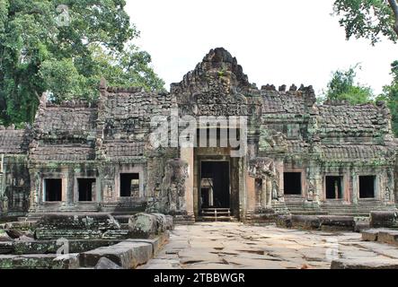 Una tipica struttura di templi in pietra nel Parco Archeologico di Angkor, Cambogia. Alle figure in piedi accanto alla porta mancano la testa Foto Stock