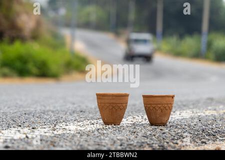 tè caldo servito in una tradizionale tazza di ceramica senza mani in argilla con un paesaggio autostradale sfocato Foto Stock