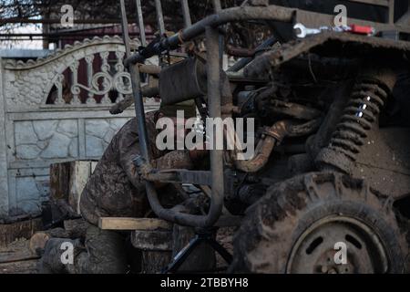 Kiev, Oblast' di Donetsk, Ucraina. 5 dicembre 2023. Un soldato ucraino lavora per riparare un piccolo veicolo di evacuazione, che ha il compito di salvare i feriti e recuperare i soldati morti. Al di fuori delle regioni di Bakhmut e Soledar, i soldati in prima linea della diciassettesima brigata si preparano per l'inverno in arrivo e continuano gli assalti russi. (Immagine di credito: © Madeleine Kelly/ZUMA Press Wire) SOLO USO EDITORIALE! Non per USO commerciale! Foto Stock