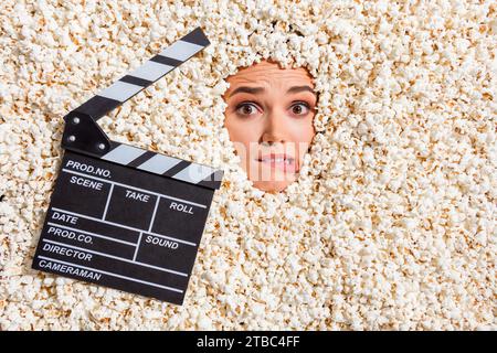 Vista dall'alto ritratto di persona preoccupata che morde labbra clapboard viso stick all'interno di uno sfondo pop corn creativo Foto Stock