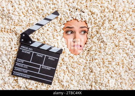 Ritratto ad alta visuale di una ragazza spaventata che morde labbra e gesso girando un film con faccia di sfondo isolato con popcorn pieno Foto Stock