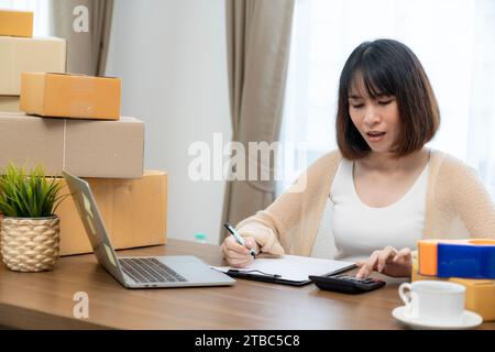 Una giovane donna che possiede una piccola attività online da casa. Foto Stock