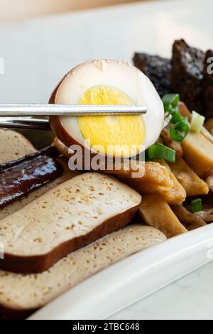 Deliziosi piatti tradizionali taiwanesi lu wei, lou mei, brasati con brodo o salsa lou in un piatto del ristorante. Foto Stock