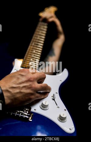 Musicista che suona la chitarra con la mano sinistra sul collo Foto Stock
